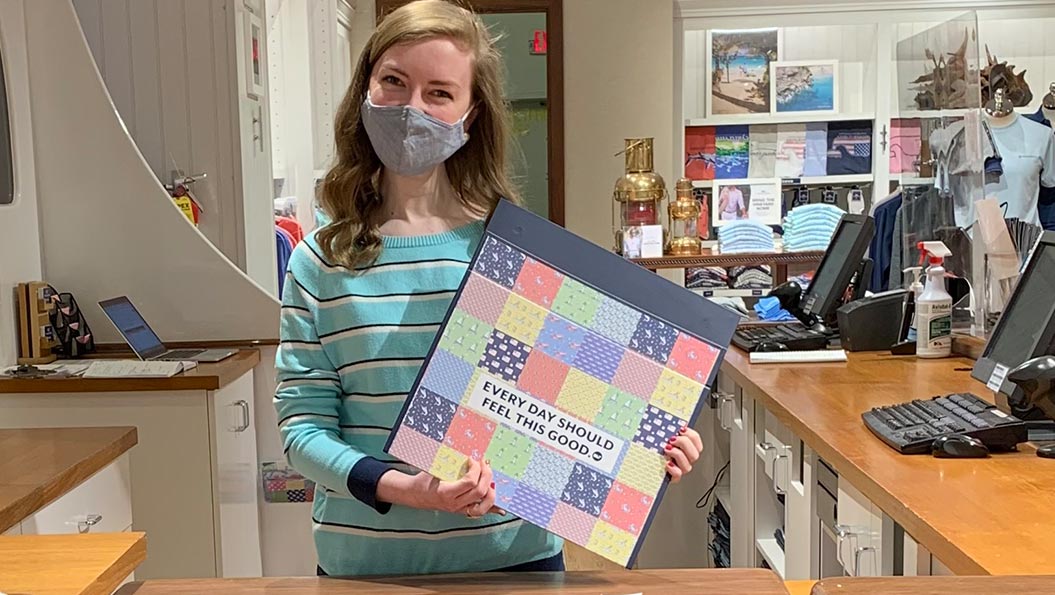 vineyard vines employee next to store table