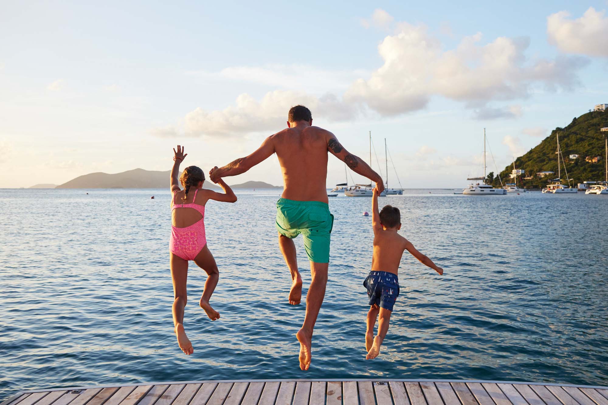 Tom Pinhold and his children jumping into water