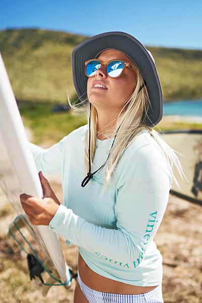 woman loading surfboard onto car
