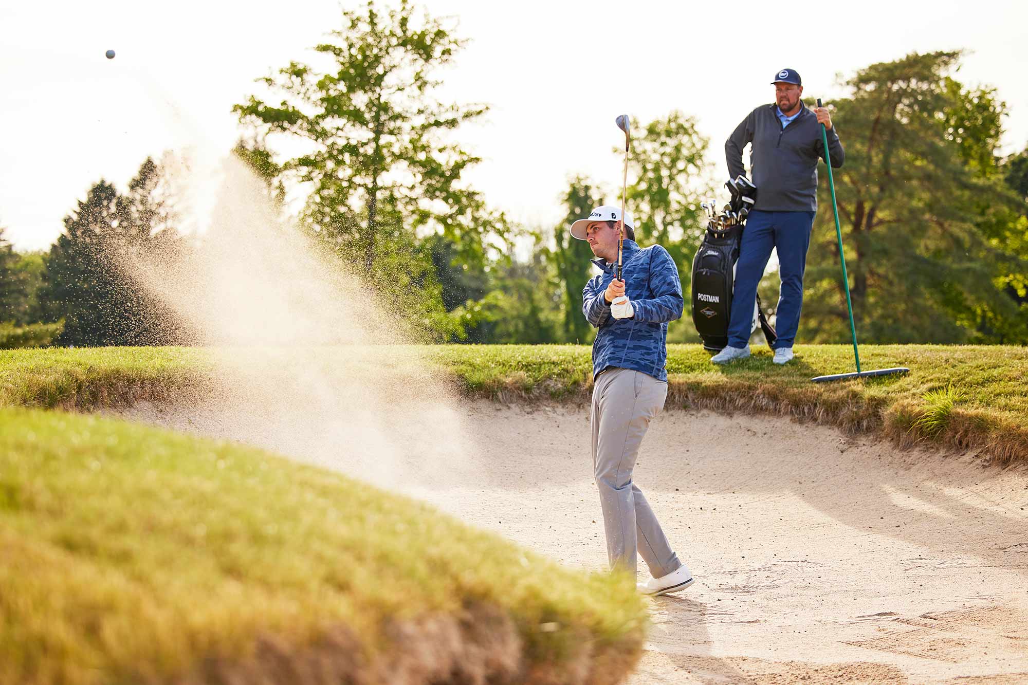 J.T. Poston in bunker with caddie
