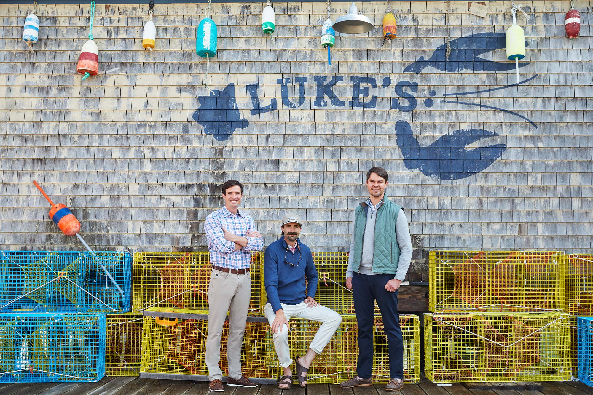 Luke, Bryan and Ben posing in front of lobster cages