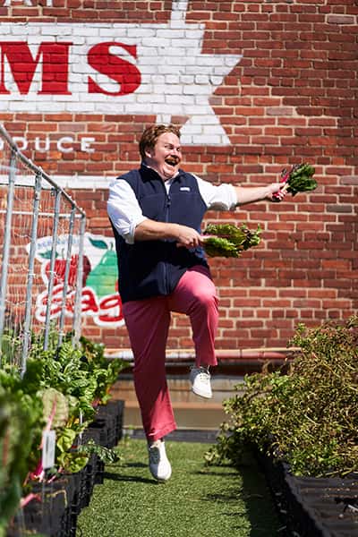 casey webb of man v food skipping through the garden wearing vineyard vines