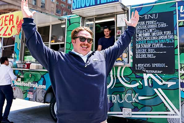 casey webb of man v food posing in front of his food truck in vineyard vines